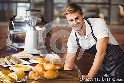 Handsome waiter leaning on a food table Stock Photo