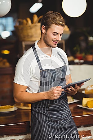 Handsome waiter using a tablet Stock Photo