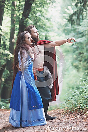 Handsome Warrior Viking man with beautiful medieval woman outdoor Stock Photo