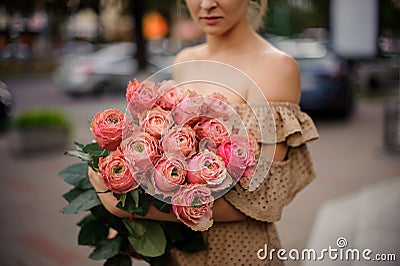 Handsome woman holds lovely bouquet of stylish bright peony roses Stock Photo