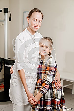 a handsome woman doctor hugs a little patient. Stock Photo