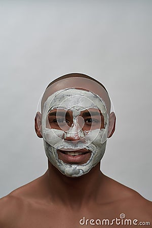 Handsome young african american man smiling at camera, using facial blackhead pore removal mask, posing over Stock Photo