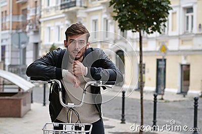 Handsome young bike messenger with backpack and rental bicycle looks at camera Stock Photo