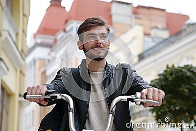 Handsome young bike messenger sits on bicycle and looks ahead Stock Photo