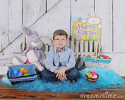 Handsome young boy sitting in Easter scene Stock Photo