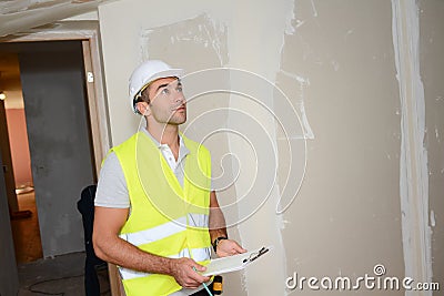 Handsome young foreman supervising a house renovation contruction site Stock Photo