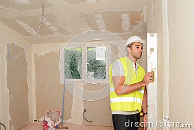 Handsome young foreman supervising a house renovation contruction site Stock Photo