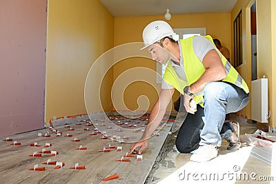 Handsome young foreman supervising a house renovation floor tiles contruction site Stock Photo