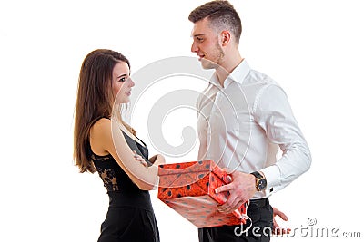 Handsome young guy in shirt standing next to the charming girl and gives her a gift Stock Photo