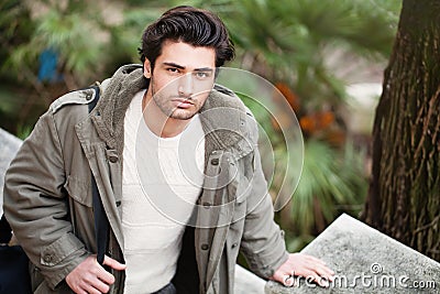 Handsome young italian man, stylish hair and coat outdoors Stock Photo