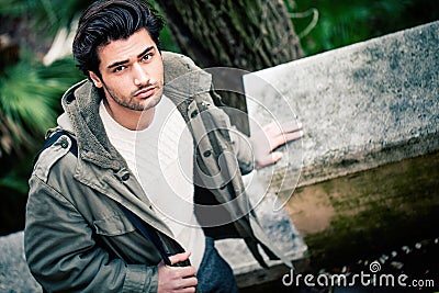 Handsome young italian man, stylish hair and coat outdoors Stock Photo