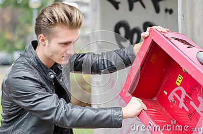 Handsome young male vandal breaking public Stock Photo