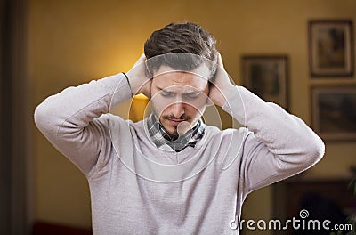 Handsome young man covering his ears, too much noise Stock Photo