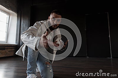 Handsome young man dancer in fashionable jacket and ripped jeans Stock Photo