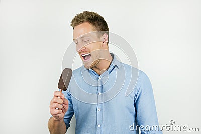 Handsome young man holding chololate ice-cream on isolated white background Stock Photo