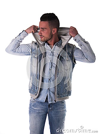 Handsome young man in hoodie, denim vest and jeans Stock Photo