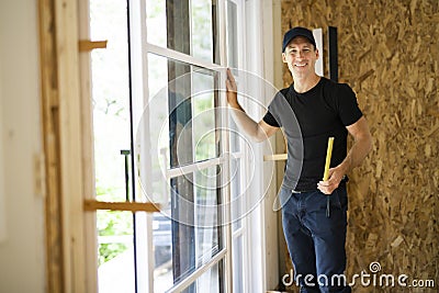 A handsome young man installing Double Sliding Patio Door in a new house construction site Stock Photo