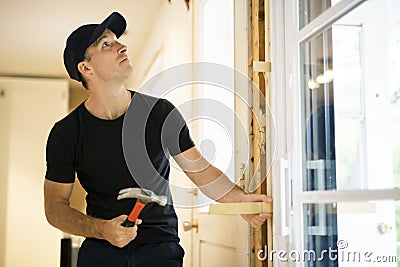 A handsome young man installing Double Sliding Patio Door in a new house construction site Stock Photo