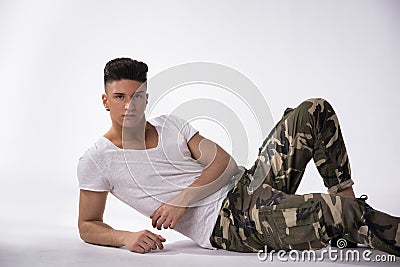 Handsome young man laying down on floor, white background Stock Photo