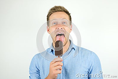 Handsome young man licks tasty chololate ice-cream on isolated white background Stock Photo