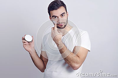 Handsome young man putting face cream Stock Photo