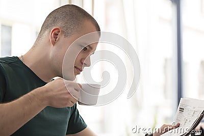 Handsome young man relaxes while drinking that first cup of coffee Stock Photo