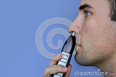 Handsome young man remove hair from his nose with trimmer Stock Photo