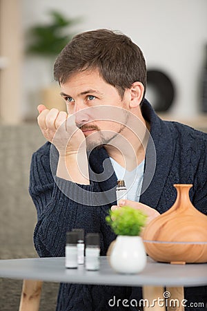 handsome young man smelling cologne or perfume on neck Stock Photo