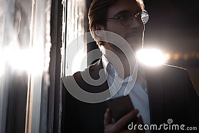 Handsome young man using smart phone during night. Closeup face of businessman messaging on cellphone at night in cafe. Stock Photo