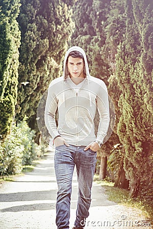 Handsome young man walking along rural road Stock Photo