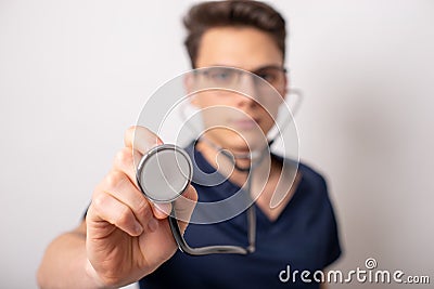 Handsome young medic holding a stethoscope, isolated over white Stock Photo