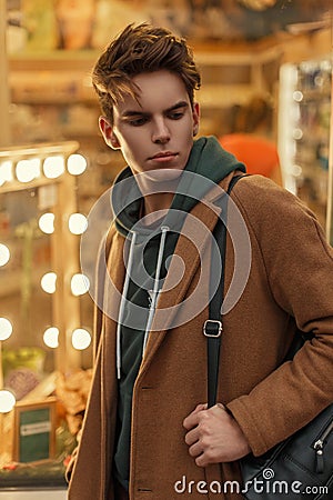 Handsome young model man with a hairstyle in a vintage coat Stock Photo