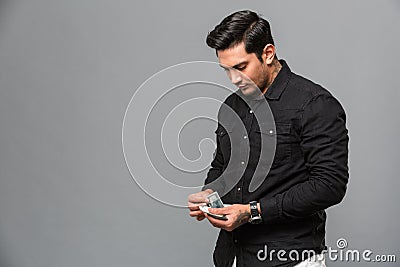 Handsome young serious concentrated man holding money. Stock Photo