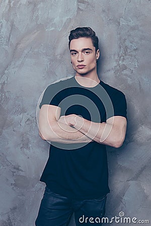 Handsome young student is standing on the grey background. He is Stock Photo