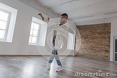 Handsome young stylish man dancer in jacket and ripped jeans Stock Photo