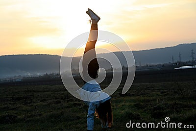 Handstanding on a field for fun Stock Photo