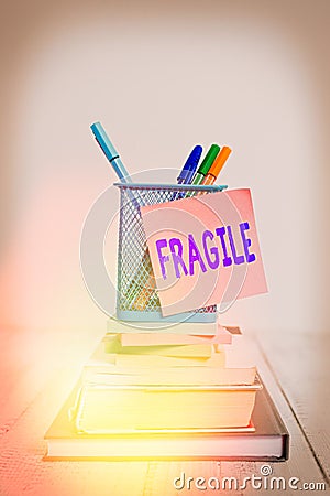 Handwriting text Fragile. Concept meaning Breakable Handle with Care Bubble Wrap Glass Hazardous Goods Stacked books pens metal Stock Photo