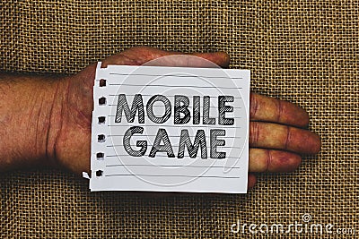 Handwriting text writing Mobile Game. Concept meaning they are entertaining programs made to work on smart device Man hand holding Stock Photo