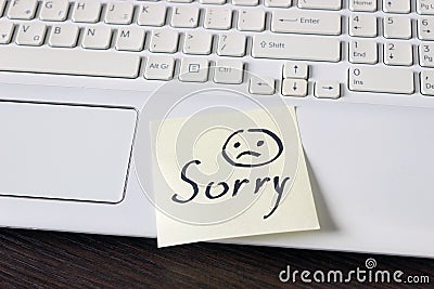 Handwritten note is on the keyboard. - Sorry. Sad smiley face dr Stock Photo