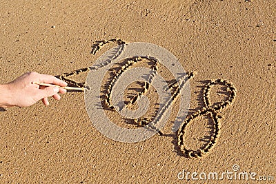 Handwritten numbers on the sand 2018 with male hand Stock Photo