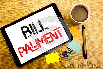 Handwritten text caption showing Bill Payment. Business concept writing for Billing Pay Costs Written on tablet laptop, wooden bac Stock Photo