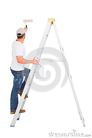 Handyman climbing ladder while using paint roller Stock Photo