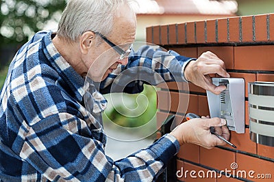 Handyman fixing intercom Stock Photo