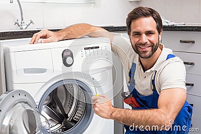 Handyman fixing a washing machine Stock Photo