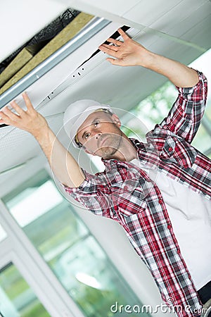 Handyman hiding cable with plinth Stock Photo