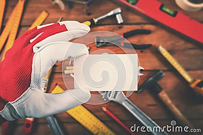 Handyman and home repair services - hand holding blank business card over the work tools Stock Photo