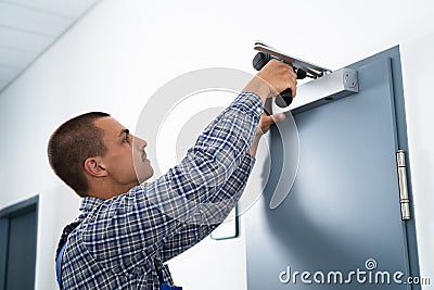 Handyman Installing And Fixing Door Closer Stock Photo