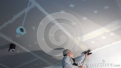 Handyman Man Spackling Gypsum Plasterboard Ceiling With Putty