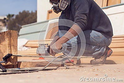 A handyman polishing wooden plank outdoor Stock Photo
