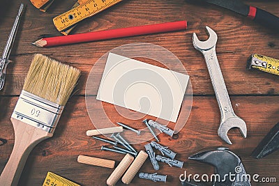 Handyman services home repair - blank business card with construction tools on wooden background Stock Photo